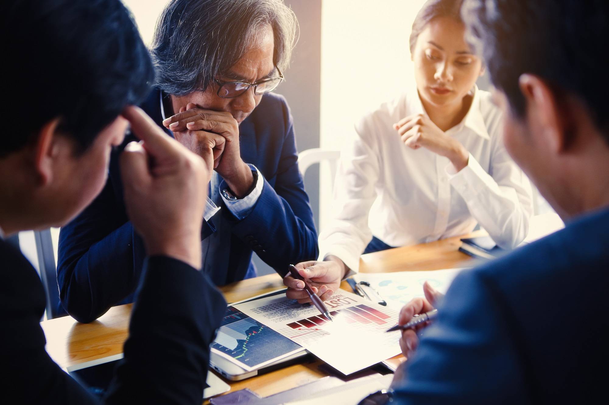 Équipe dirigeante en réunion de travail autour de documents d'analyse